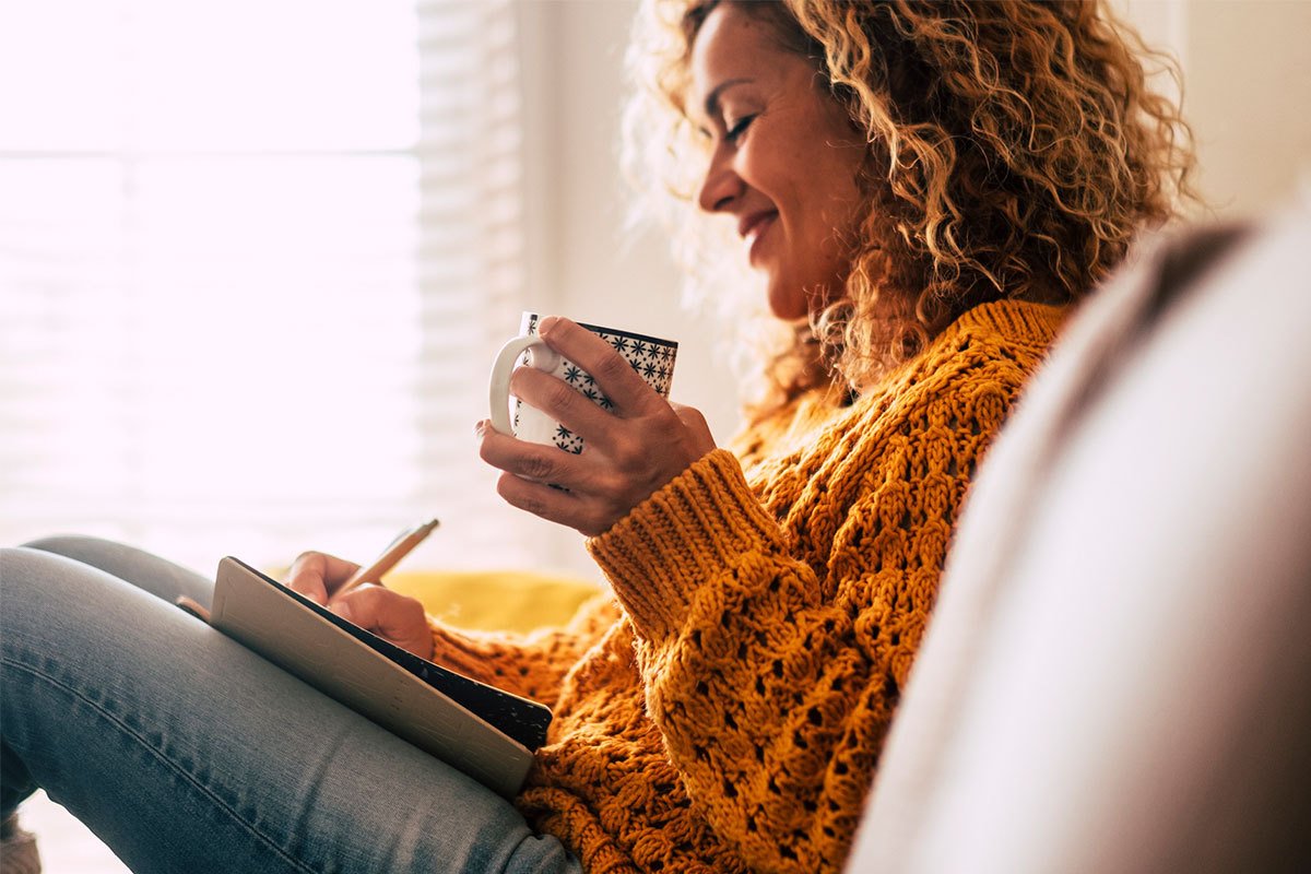 Woman drinking a cup of coffee and reading