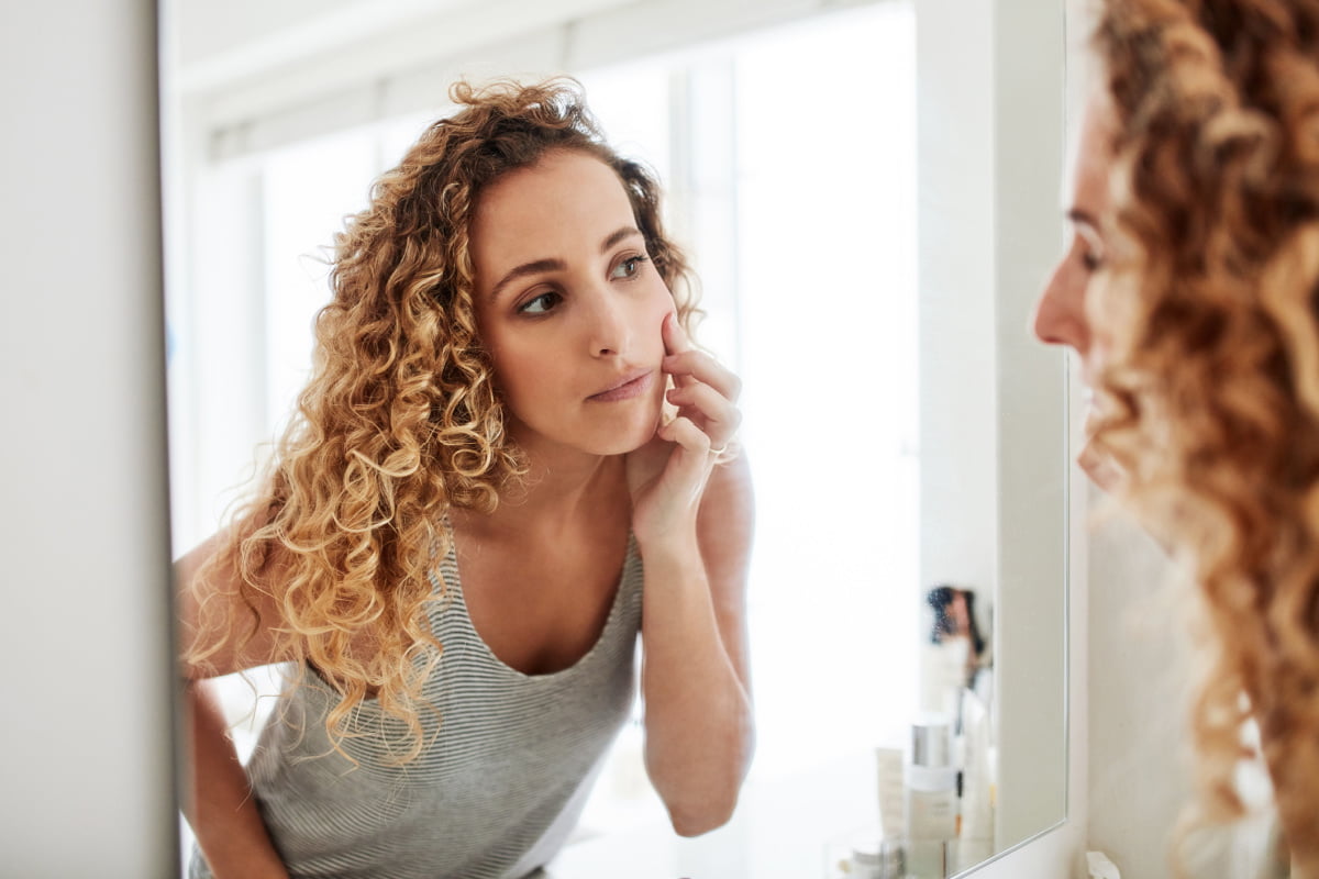 Woman Checks Dermal Fillers in Mirror for Sign of Movement and Migration