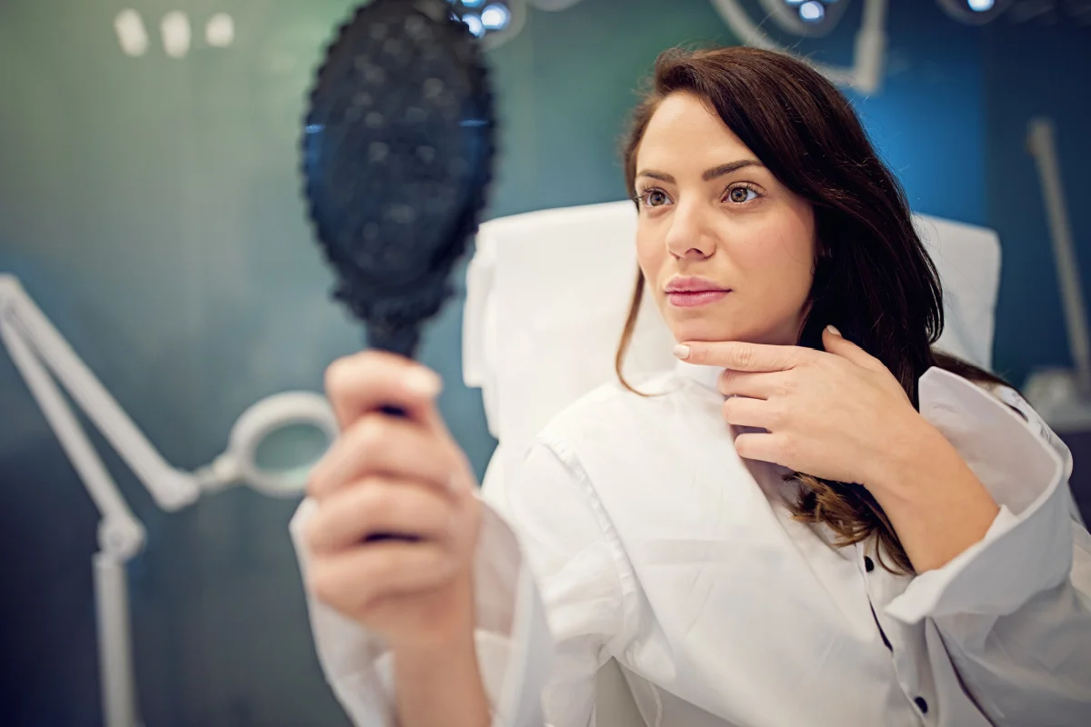 Woman Looks in Mirror After Thread Lift at Kalos Medical Spa in Fort Worth