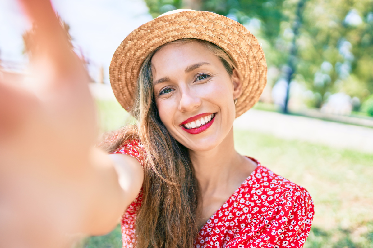 Smiling blonde woman taking a selfie at an Instagram spot in Fort Worth