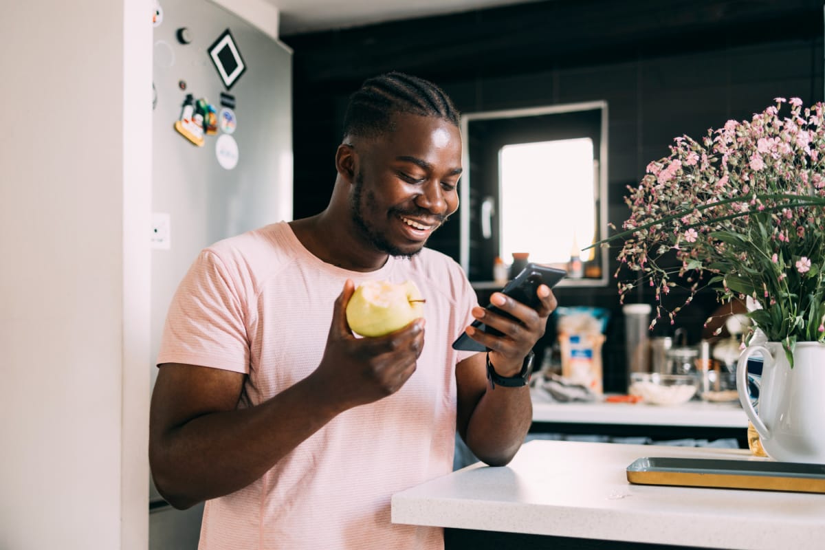 Man using ShapeScale app on phone to track body transformation progress