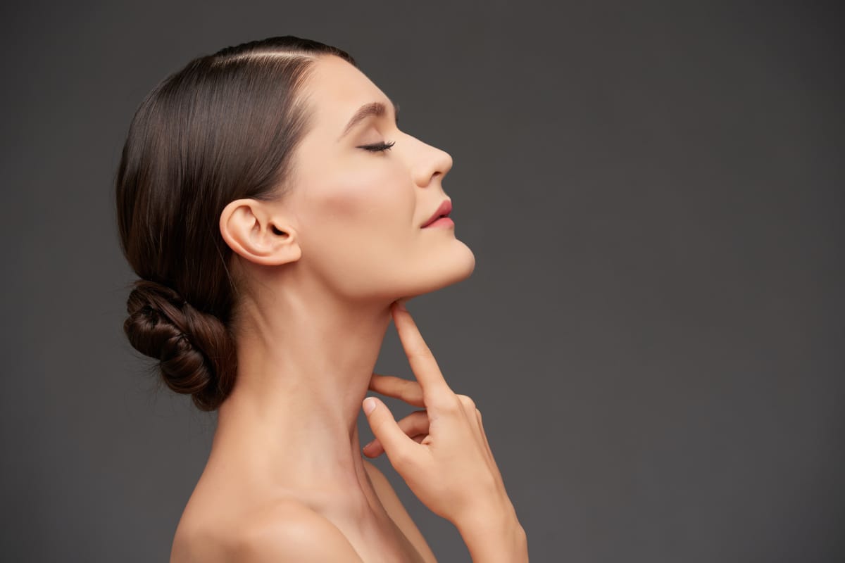 Woman touching neck after injectable neck rejuvenation treatment