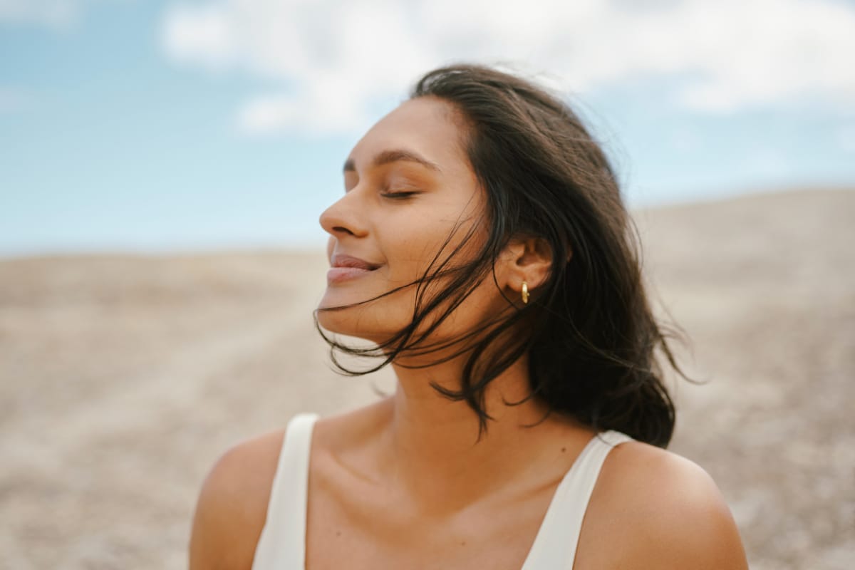 Young woman with tan skin during summer standing in the sun