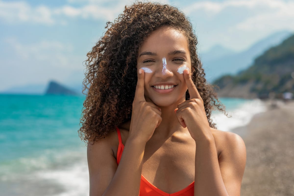 Gen Z woman sunscreen contouring at the beach after seeing it as a beauty hack on TikTok