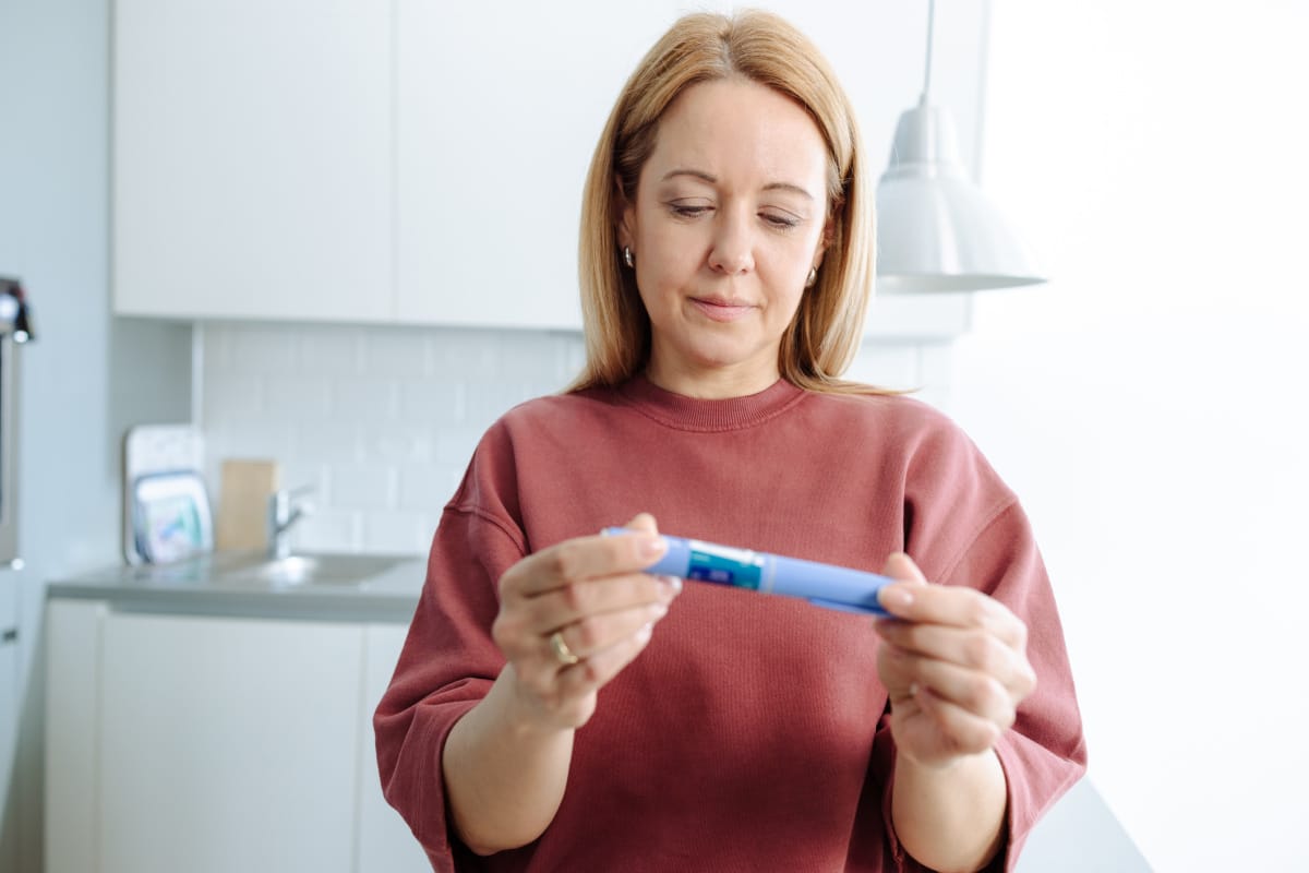 Woman in the kitchen about to self-administer glp-1 injections