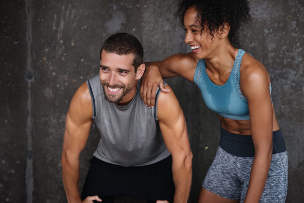 Young fit man and woman in workout clothes